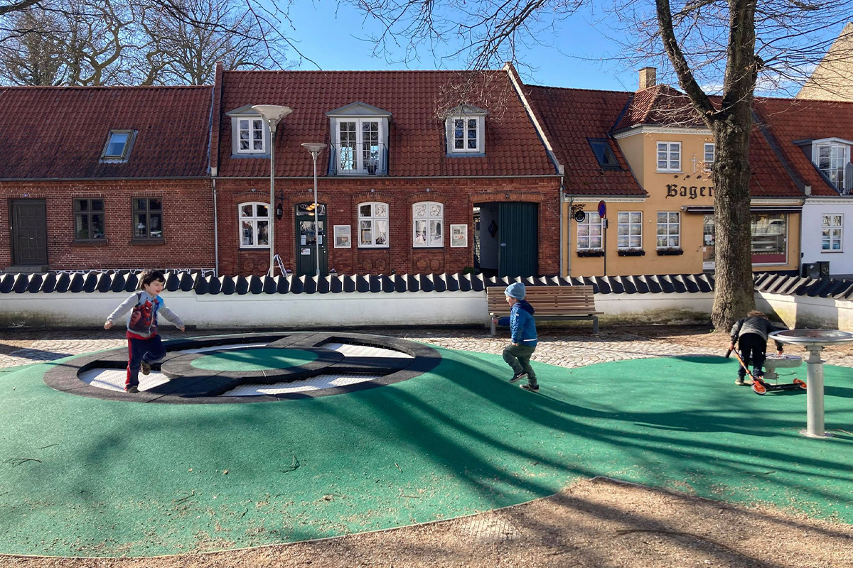 Tre børn leger på legepladsen på Maribo Torv