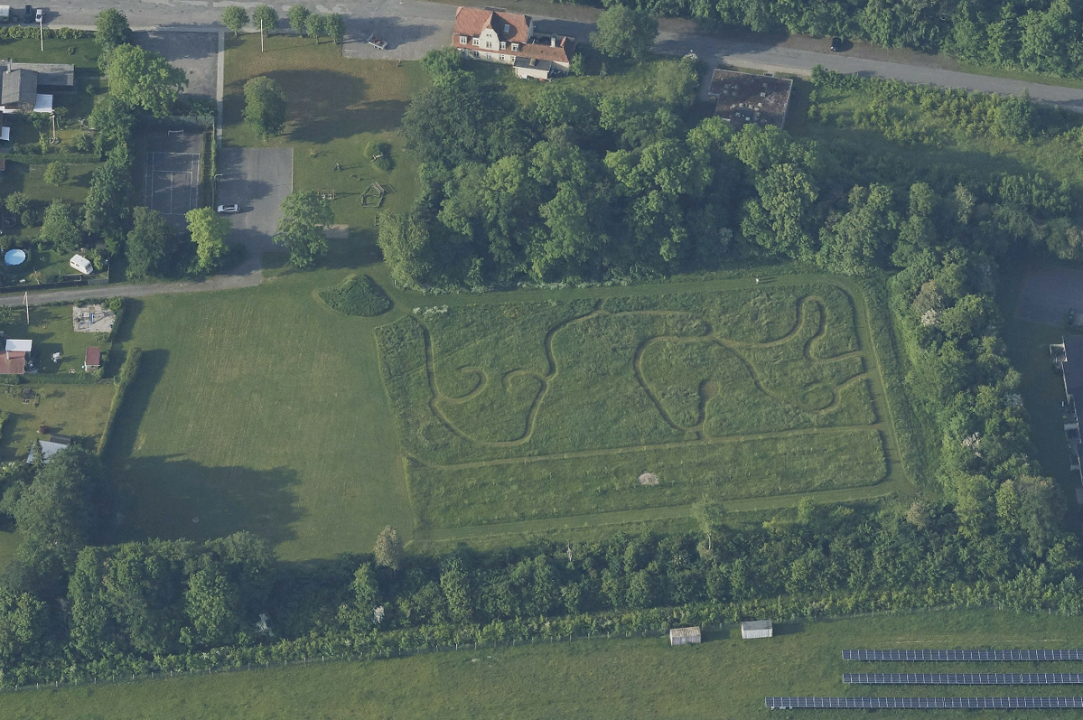 Et luftfoto af hele byparken, hvor man kan se hvordan der er lavet en græs labyrint i et stort område. 